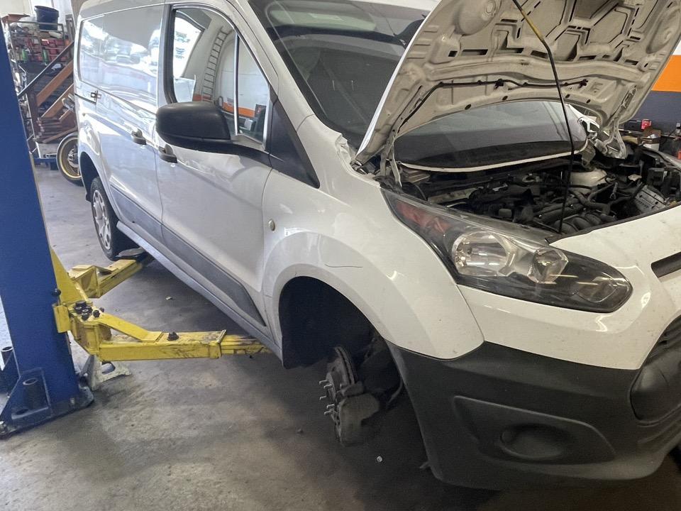 Van on the lift with the front wheel removed for a brake inspection at 415 Mechanix in Potrero Hill