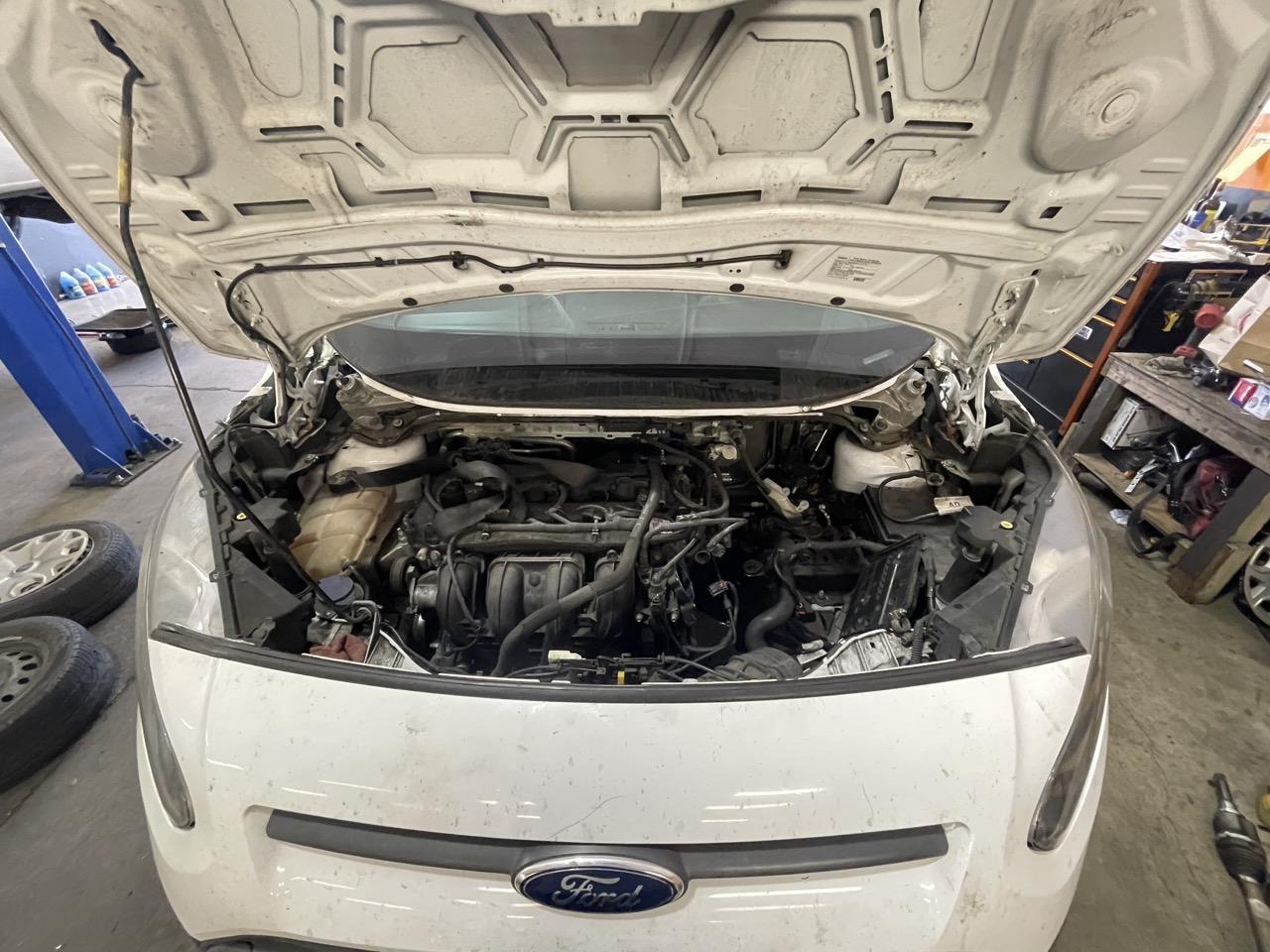 Open engine bay of a white Ford van at 415 Mechanix during a check engine light diagnosis in San Francisco