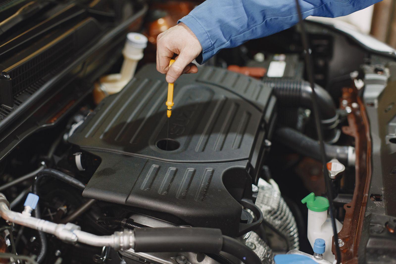 Mechanic pulling the engine oil dipstick to check the oil level