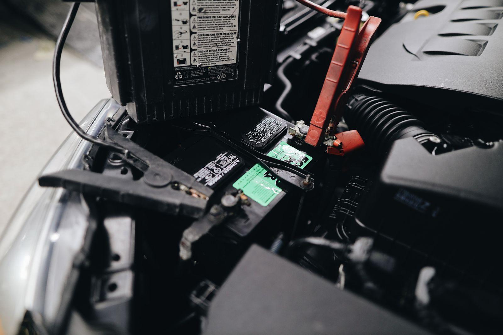 Jumper cable clamps attached to a car battery's terminals